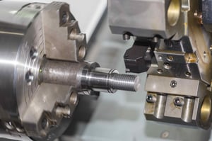 The chuck here holds a workpiece in place, while the tool shaves away pieces to shape the workpiece.
