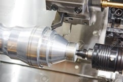 A part being shaped in a swiss turning machine.